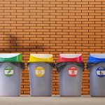 multi-colored-garbage-bins-on-pavement-with-blurre-2023-11-27-04-53-02-utc